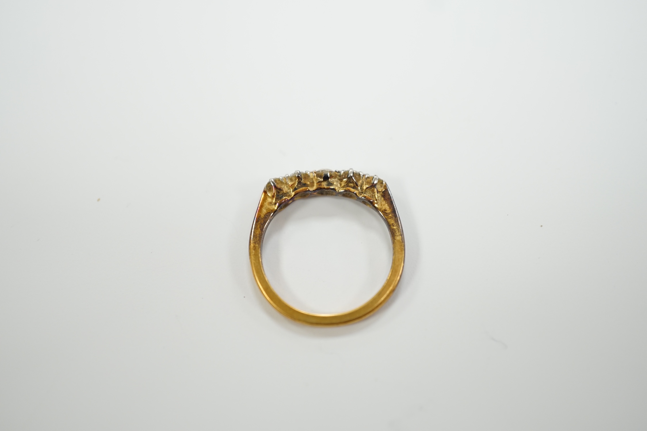 An early 20th century 18ct, plat and graduated five stone diamond chip set half hoop ring, size H, gross weight 2.2 grams.